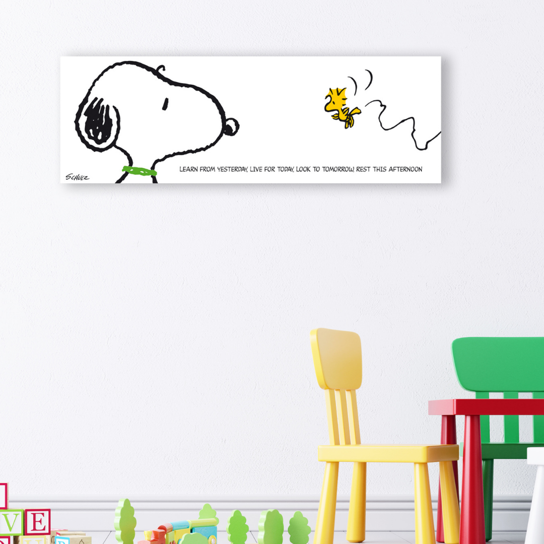 Snoopy seduto sulla sua cuccia, contempla la vita, con una bolla di citazione in italiano e inglese che riflette sull'imparare da ieri, vivere per oggi e restare nel pomeriggio. Tela in stanza Giochi