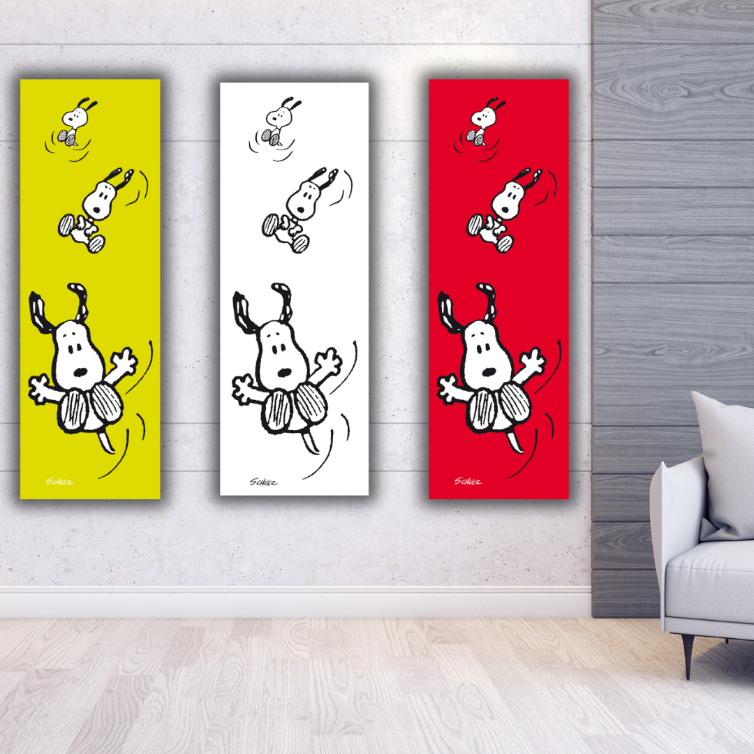 Tre stampe verticali affiancate di "SNOOPY che vola" di Charles Schulz, con sfondi bianco, verde acido e rosso, mostrano Snoopy in diverse pose aeree.